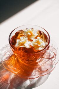 A beautifully crafted transparent tea cup adorned with floating daffodils, embracing a vintage aesthetic.