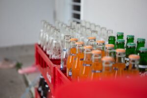 A collection of various bottled soft drinks in red crates, showcasing vibrant colors and popular brands.